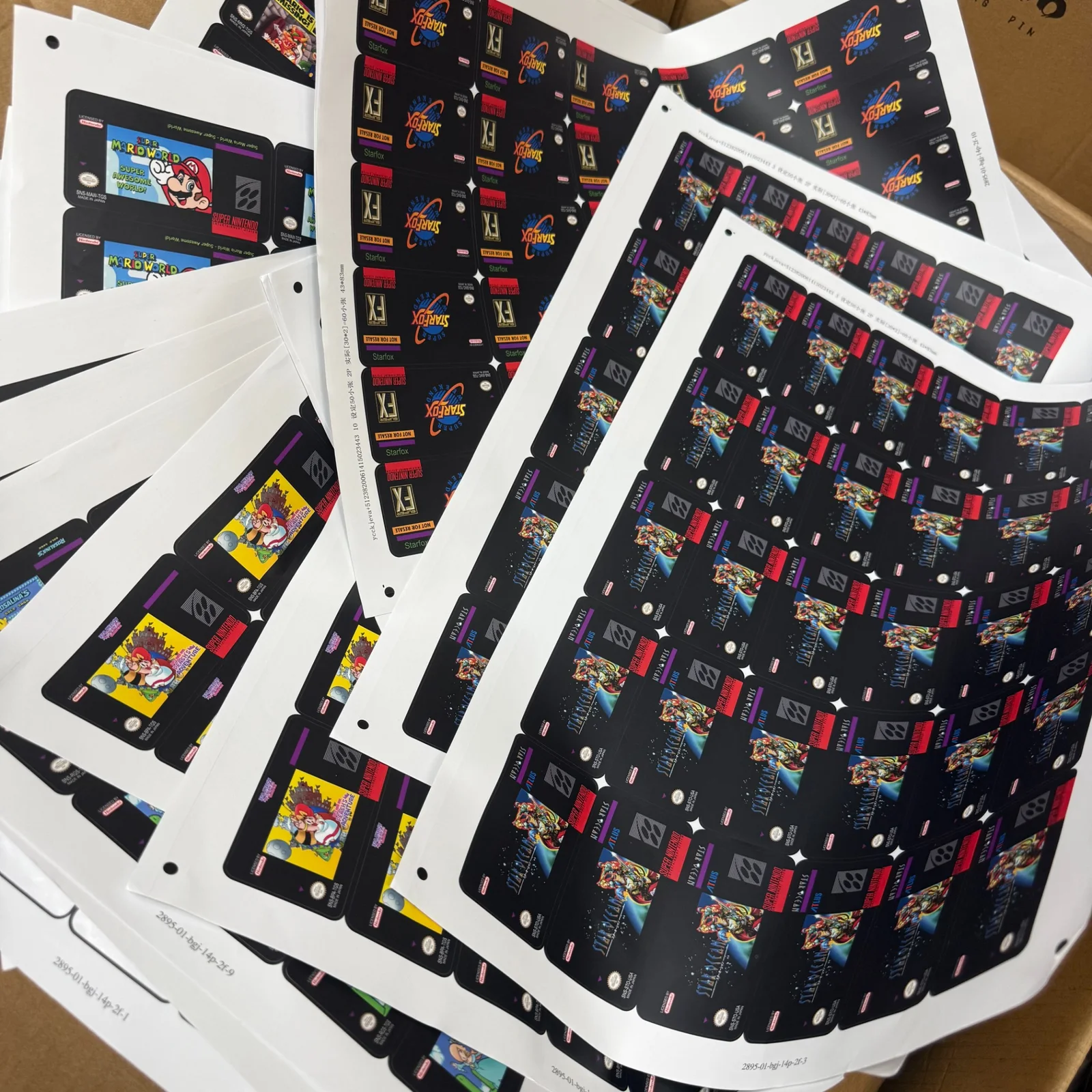 Real product archive photograph of printed label sheets (customer artwork examples)